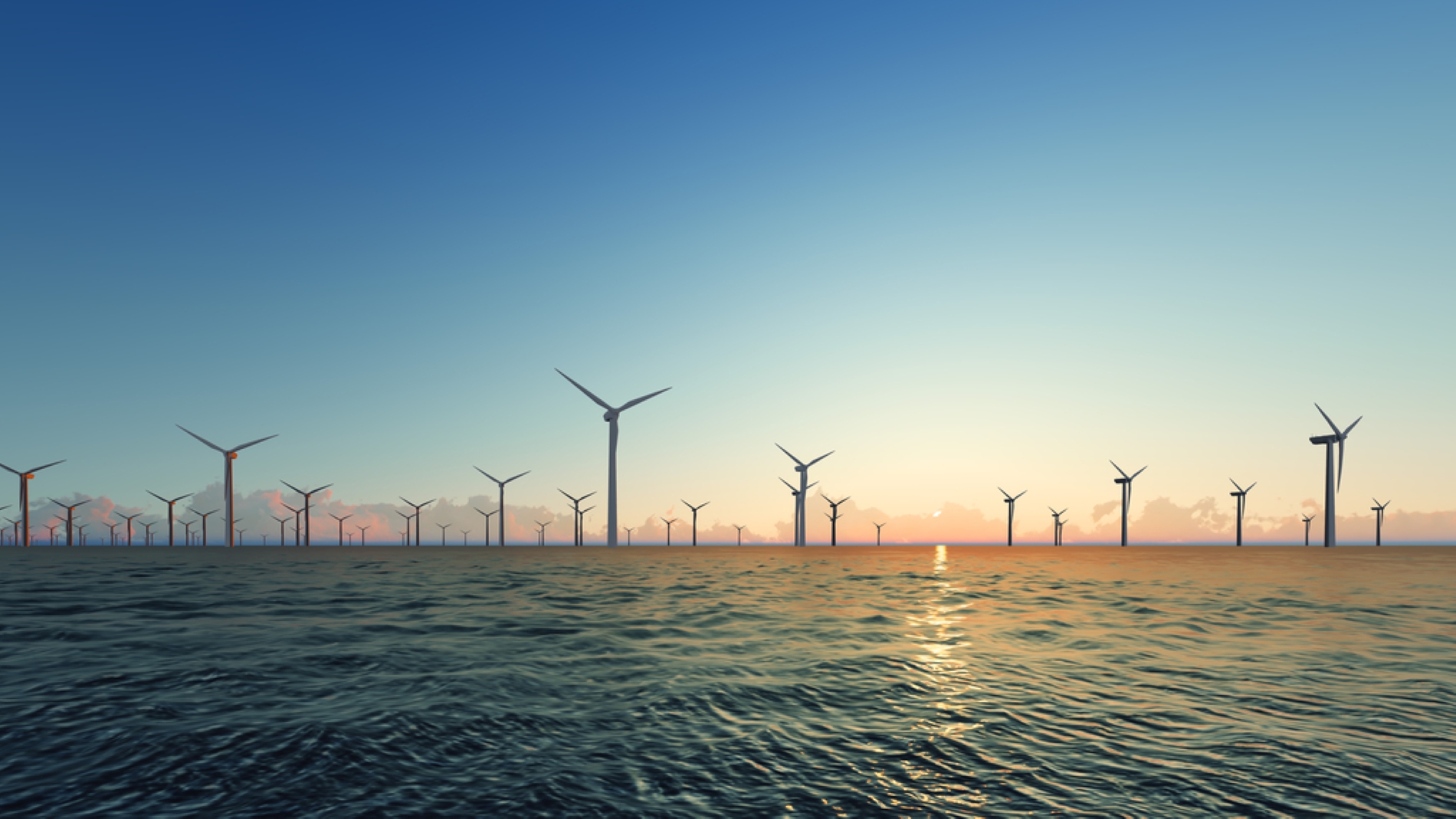 Wind turbines in a field with sunset in the background