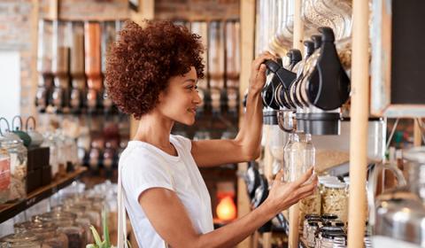 Lady putting food in a jar 