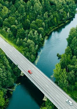 Route vue du ciel avec des voitures, une rivière bleue et des arbres