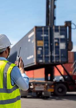 Auditor monitoring container handling operations at a shipping container yard