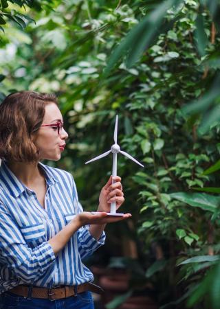 Woman blowing on a smell wind turbine