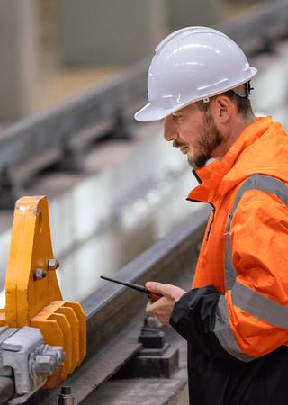 Engineer assessing rail infrastructure and implementing maintenance upgrades